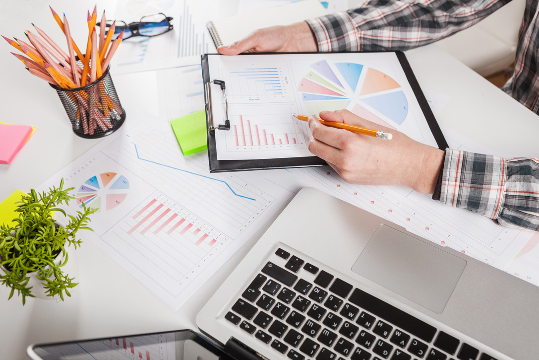 Businessman holding a pen is working with graph documents.